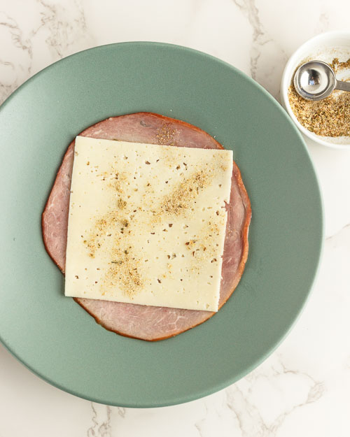 Sprinkling the spices on the ham.