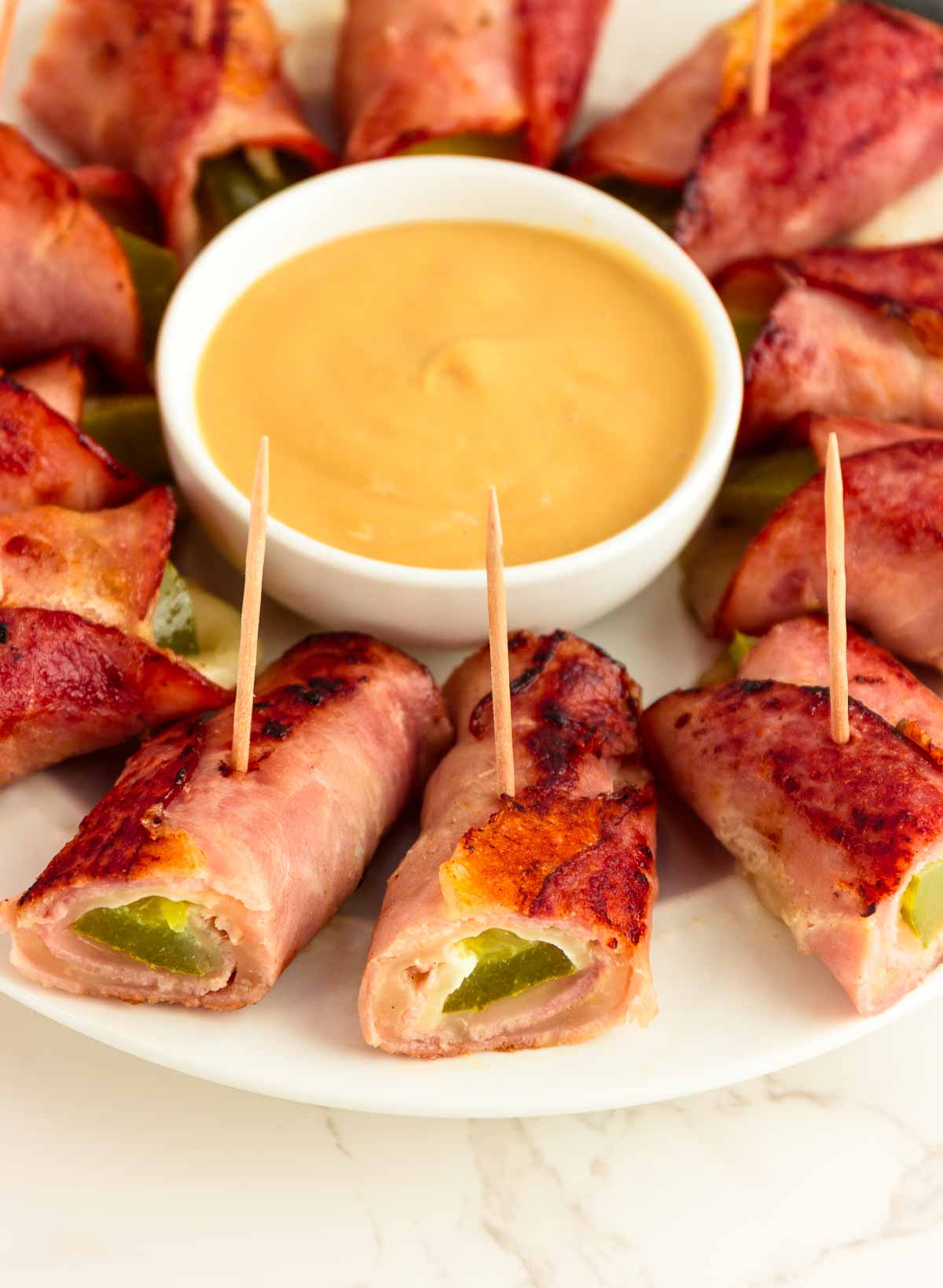 A platter of keto Cubano roll ups with a honey mustard dip.