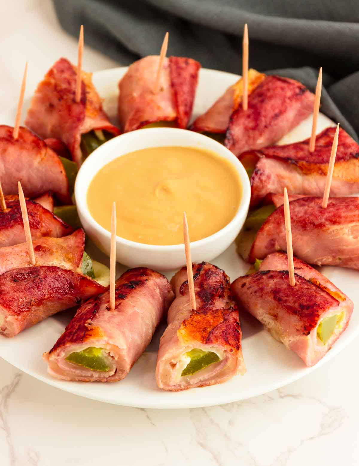 A platter of keto Cubano roll ups with a honey mustard dip.