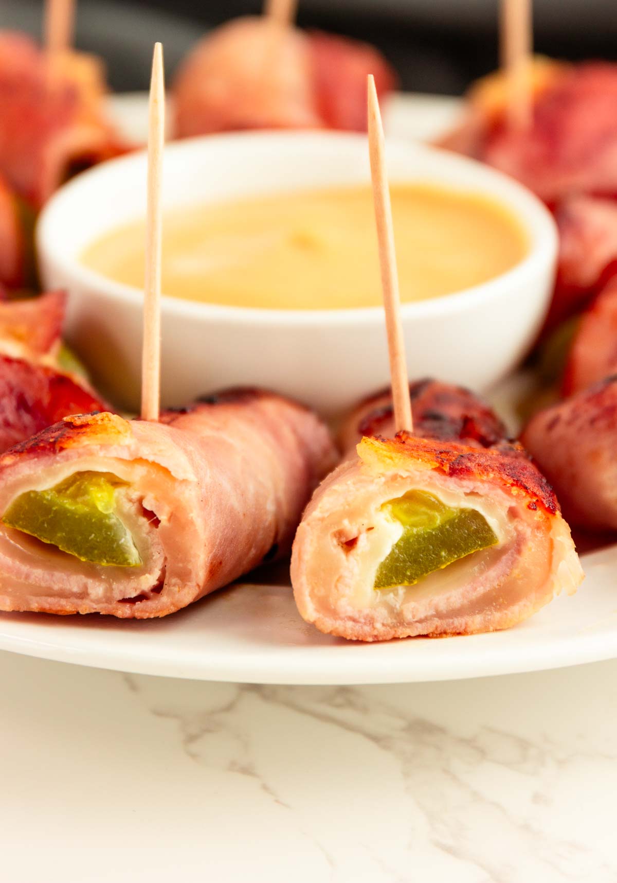 A platter of keto Cubano roll ups with a honey mustard dip.