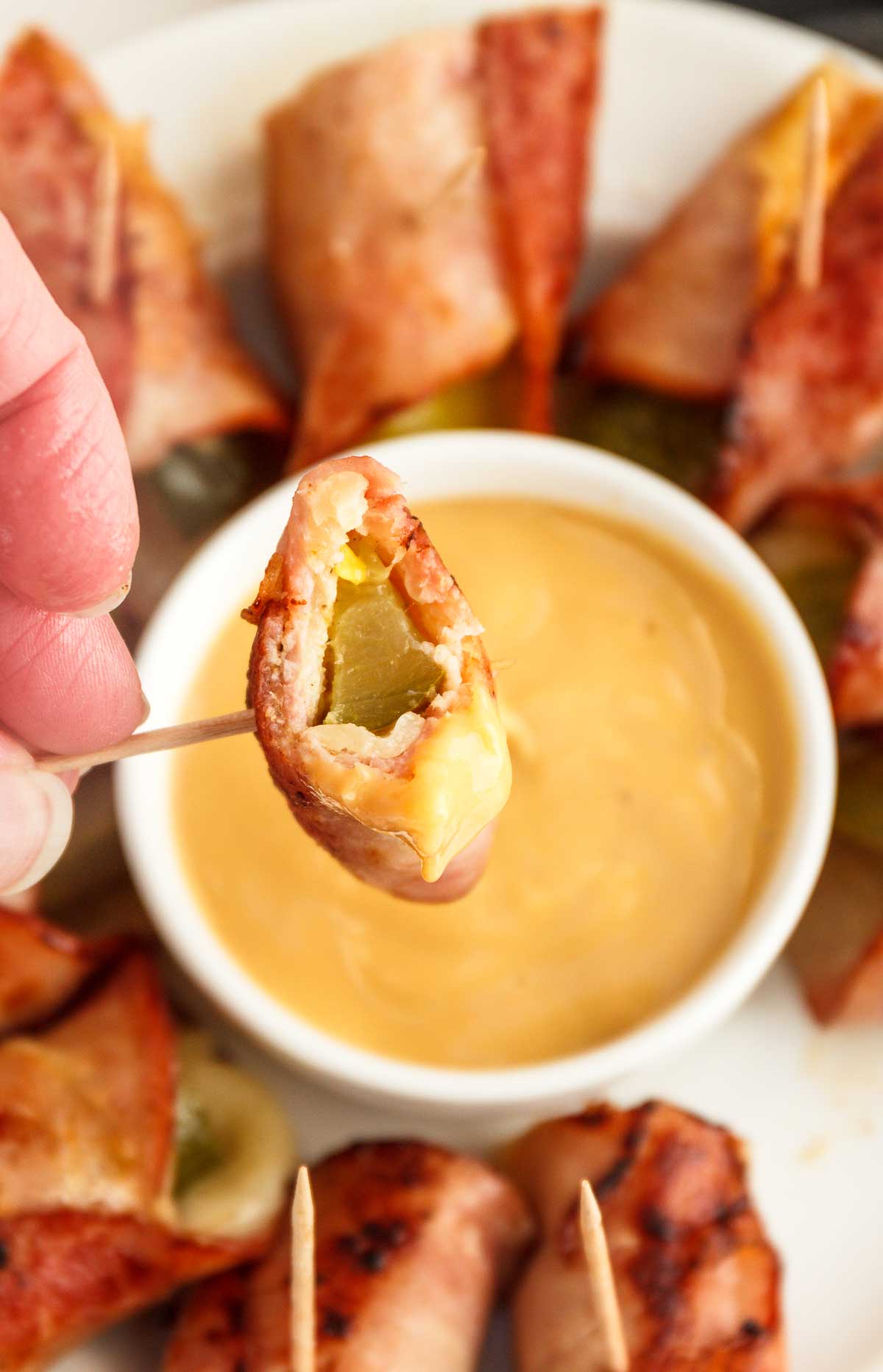 Dipping a Cubano Roll Up in keto honey mustard.