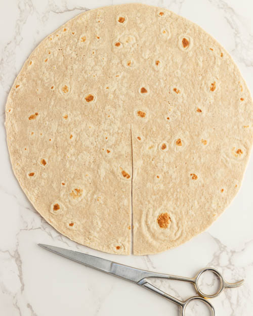 Cutting a line halfway up a tortilla.