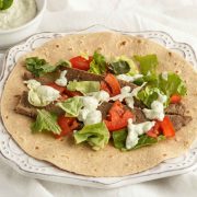 Beef gyro meat with veggies and tzatziki sauce on a low carb wrap.
